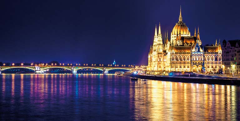 A view from the Danube River towards the Hungarian Parliament Building illuminated at night, Hungary